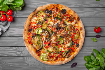 Tasty hot italian pizza with eggplant, zucchini, peppers, tomatoes and cheese. Pizzeria menu. Concept poster for Restaurants or pizzerias. Top view