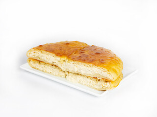 Pie with cottage cheese cut in half lies on a rectangular plate side view
