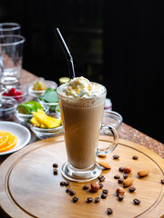 Tall glass goblet filled with coffee drink and decorated with whipped cream