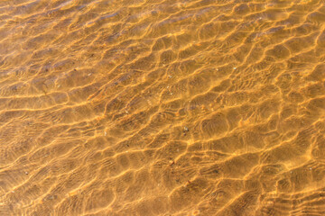 Fototapeta na wymiar Texture of ripple sea water with sand bottom for background