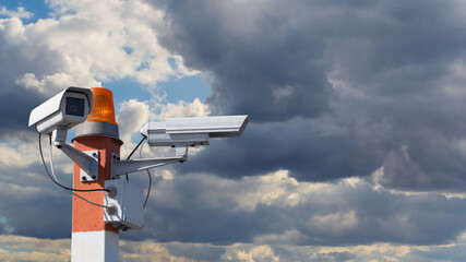 Naklejka na ściany i meble Security cameras on pillar against the cloudy sky
