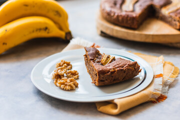 View of a homemade round banana bread with bananas and walnuts.