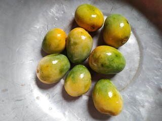 Green and yellow mangoge natural food on a wooden table 