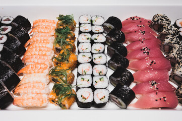 Assorted sushi and roll on a white bar. Tuna sushi, seaweed roll, prawn sushi