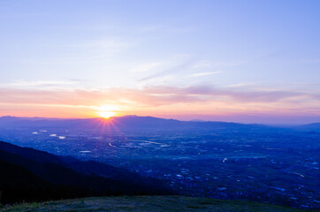 山に沈む夕焼けと河と平野