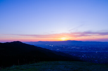 山に沈む夕焼けと河と平野