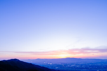 山に沈む夕焼けと河と平野
