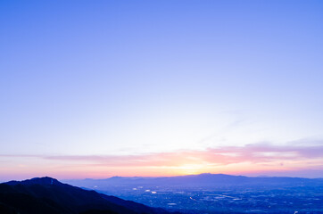 山に沈む夕焼けと河と平野