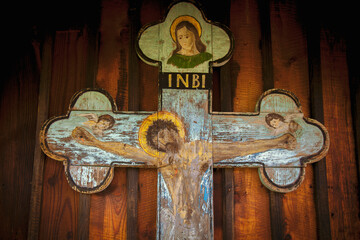 Very ancient partly destroyed wooden cross with Jesus Christ. Horizontal image.