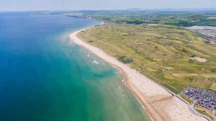 Aerial view on sandy Beach and coast of Atlantic Ocean in Portrush Northern Ireland, Top view on small coastal town 