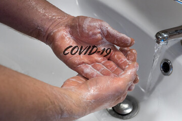 Fototapeta premium Hand washing, Basic protection against coronvirus infection, Soapy hands with the inscription Covid-19