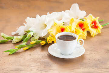 Obraz na płótnie Canvas coffee and gladioluses on a table, selective focus