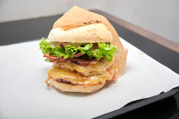 Double cheeseburger in a plastic tray and paper tablecloth