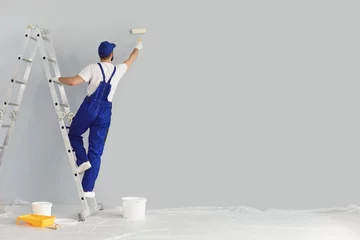 Foto op Aluminium Building contractor painting grey wall with roller brush, copy space text. Construction worker renovating house © Studio Romantic
