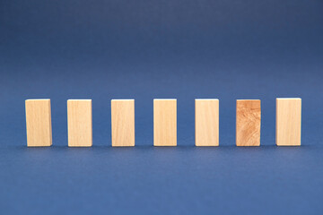 7 bûchettes bois rectangles alignées sur fond bleu 