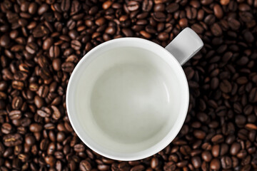 white cup on coffee beans