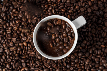 coffee in a white cup on a background of coffee beans, coffee grains on coffee foam
