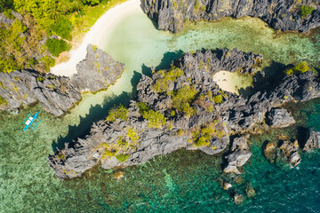 El Nido Palawan National Park. Hidden lagoon surrounded by lime stone rocks. White beach on tourist routes in the Philippines. Rocky formations on a tropical beach