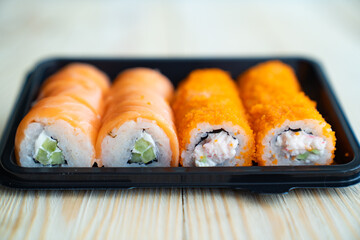 Fototapeta na wymiar rolls in a black container. food delivery to the house.