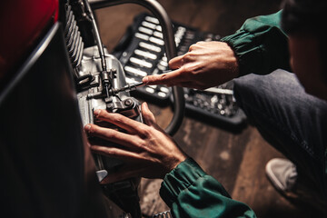 Male hands close-up with wrenches. The auto mechanic works in the garage. Repair service.