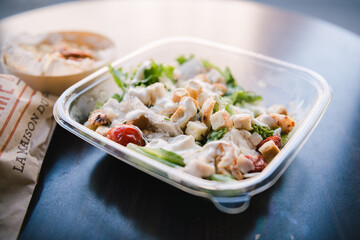 A bowl delicious and healthy chicken lettuce salad in natural light