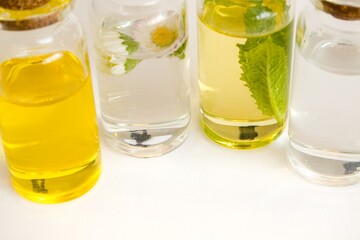 Beautiful photo of small bottles with cork stoppers filled with fantastic fragrant oil, essential oils, peppermint, rose water and daisies