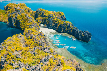 Tourist boats on tour in big and lagoon, aerial view. Tropical landscape. El Nido, Palawan island, Philippines