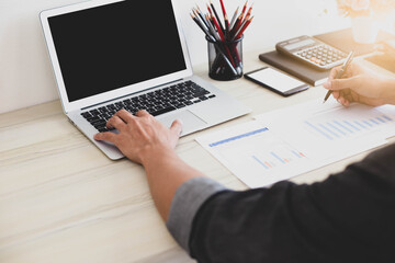 businessman working on desk work ,close up hand on keyboard  laptop with stationaries item in office.