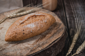 rustic crusty loaves of delicious fresh bakery bread and buns on cutting board.on a wooden table. top view. flat lay.