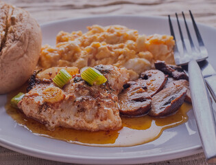 Pan seared cod fillet with mushrooms and scrambled eggs.