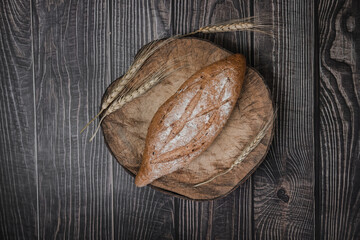 rustic crusty loaves of delicious fresh bakery bread and buns on cutting board.on a wooden table. top view. flat lay.