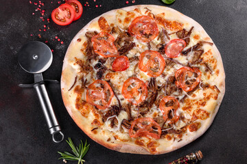 Fresh hot pizza with meat, mushrooms, cheese and tomatoes made in an oven