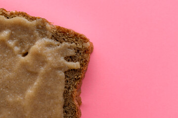 Piece of bread with pollock caviar. Pink background.Concept of a quick sandwich, snacks.