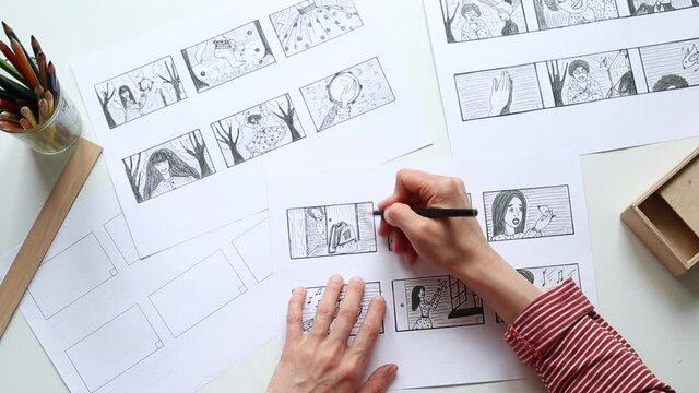 Hands of the artist designer draw a storyboard on paper. Storytelling. Story frames with heroes.