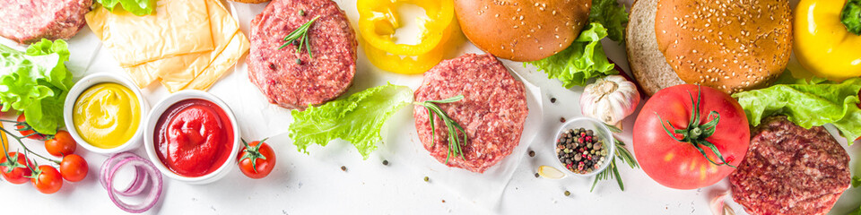 Cooking burger background. Set various cheeseburger  and beefburger ingredients - bun, tomatoes, onion, lettuce, sauces, cheese and raw burger cutlets, ready for barbecue grill. Burger bbq party fest 