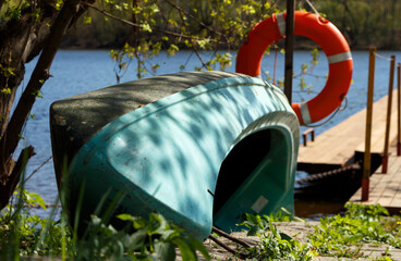 An upturned canoe lies on the beach, next to a lifeline.