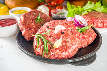 Cooking burger background. Set various cheeseburger  and beefburger ingredients - bun, tomatoes, onion, lettuce, sauces, cheese and raw burger cutlets, ready for barbecue grill. Burger bbq party fest 