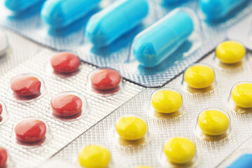 pile of medical pills  in red, blue colors in  silver plastic packaging