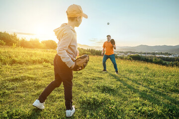 Father and son playing in baseball. Playful Man teaching Boy baseballs exercise outdoors in sunny...