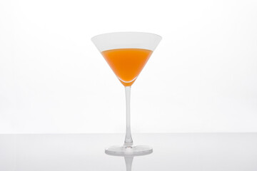 Cocktail glass with orange juice on white background