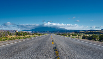The road intersects the plain and rests against the mountains.