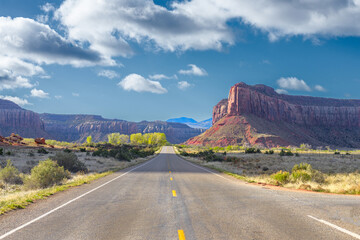 The road passing through the prairie against the backdrop of a mountain landscape.