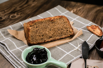 Top view fresh homemade banana bread and sliced bread on cutting board with jam strawberry and blueberry on wooden background.Healthy Diet.Prepared from a dough of flour and water, usually by baking.