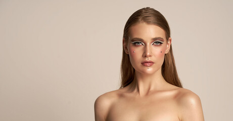 Obraz premium The beautiful face of a young woman with clean fresh skin is closely isolated on white. concept of care for young people and skin