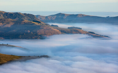 Silhouette of mountains in the misty morning. View of the mountains in early winter. Beautiful nature landscape. Bank Peninsula, Robinsons bay, Canterbury, Ndw Zealand.