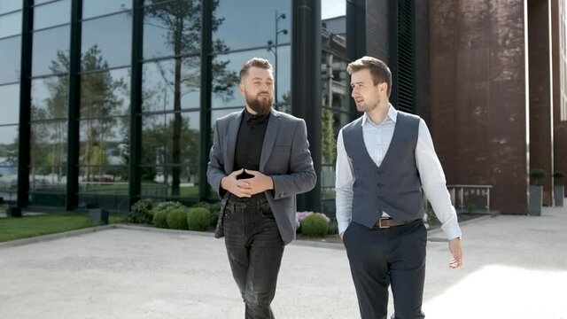 Young beard businessmen walking and talking about business in crises. Business building background.