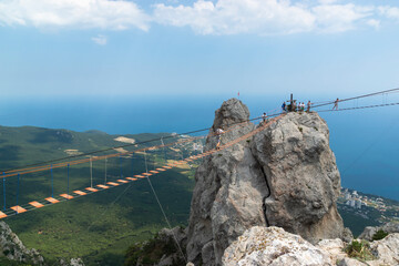 Suspension bridge on Mount Ai-Petri, Crimean Peninsula. Thrill attraction. Mountain peaks with sea view.