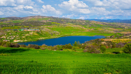 Fototapeta na wymiar green mountain valley with small lake, countryside outdoor scene