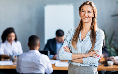 Successful Businesswoman Posing Standing In Modern Office During Meeting