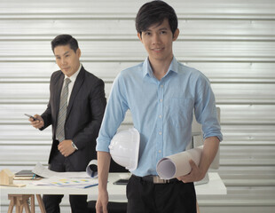  Architect or engineer or foreman hold blueprint and construction helmet is standing.